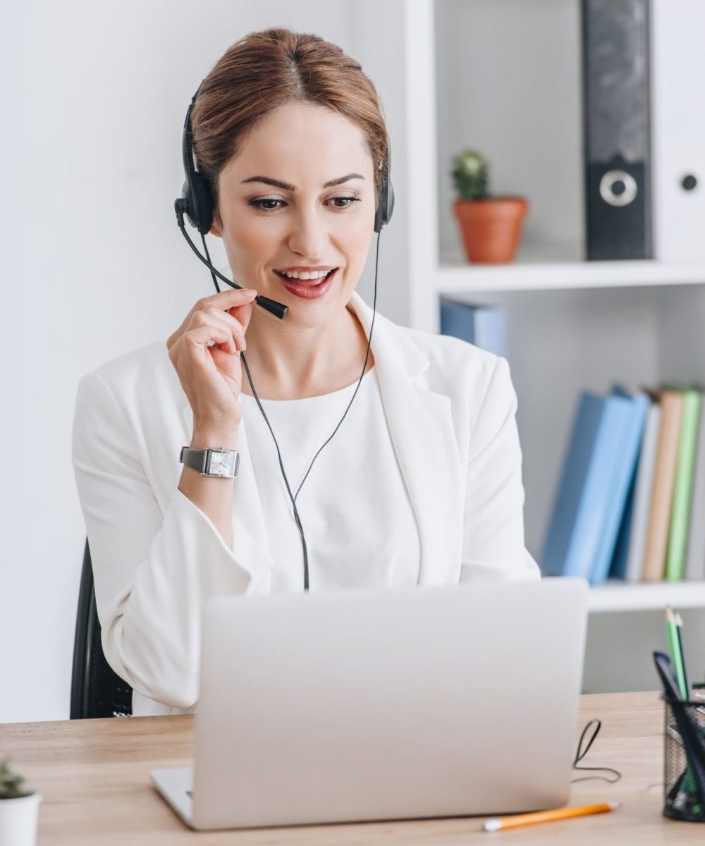 beautiful-female-operator-working-with-headset-and-laptop-in-modern-office-e1639551945790